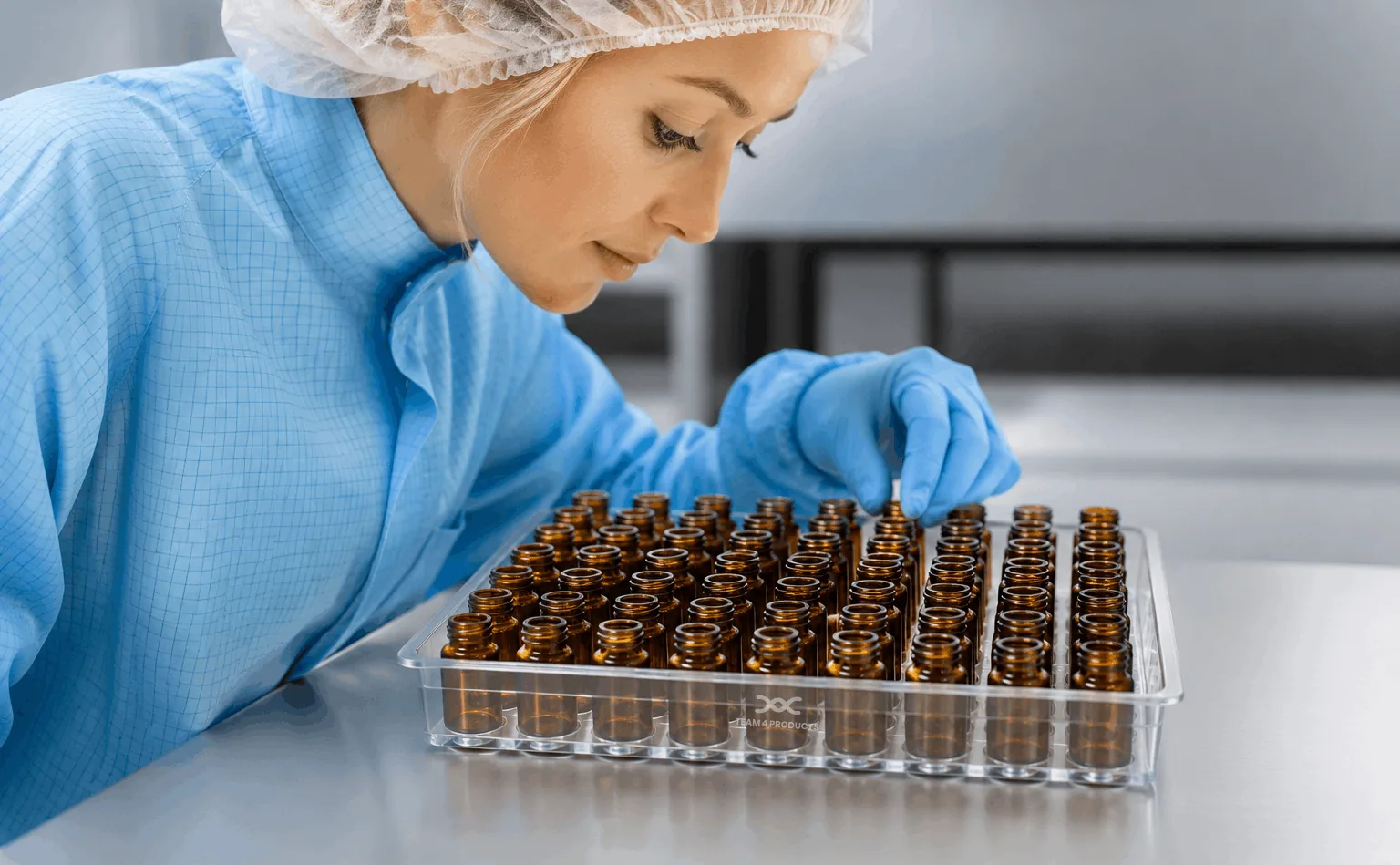Technician inspecting a Team 4 tray of amber 6R vials